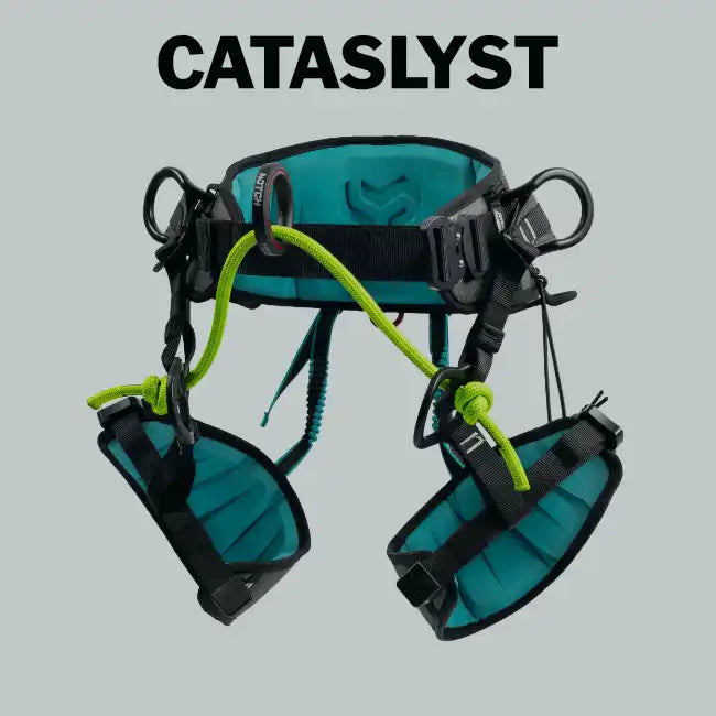 Teal and black climbing harness with bright green ropes.